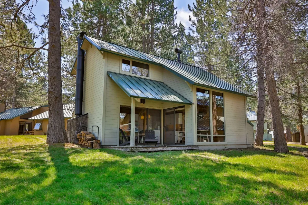 The exterior patio area with porch seating, surrounded by trees. The space feels peaceful and is perfect for relaxing or grilling outdoors, capturing the essence of al fresco dining and enjoying nature.